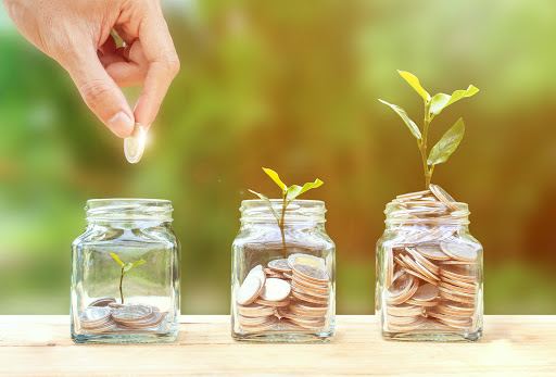 hand dropping a quarter in a money jar depicting a kasasa checking account.