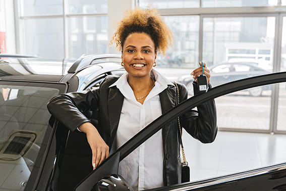 Woman with a new car after getting credit union auto loan pre-approval