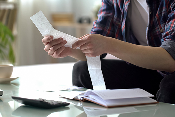 someone with paperwork in their hand practicing wise money management.