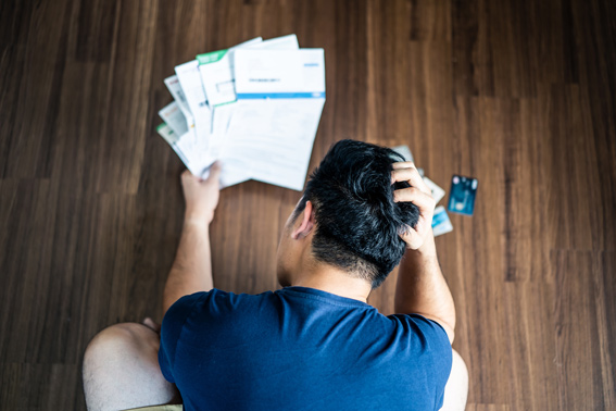 a man scratching his head as he looks at debt consolidation papers