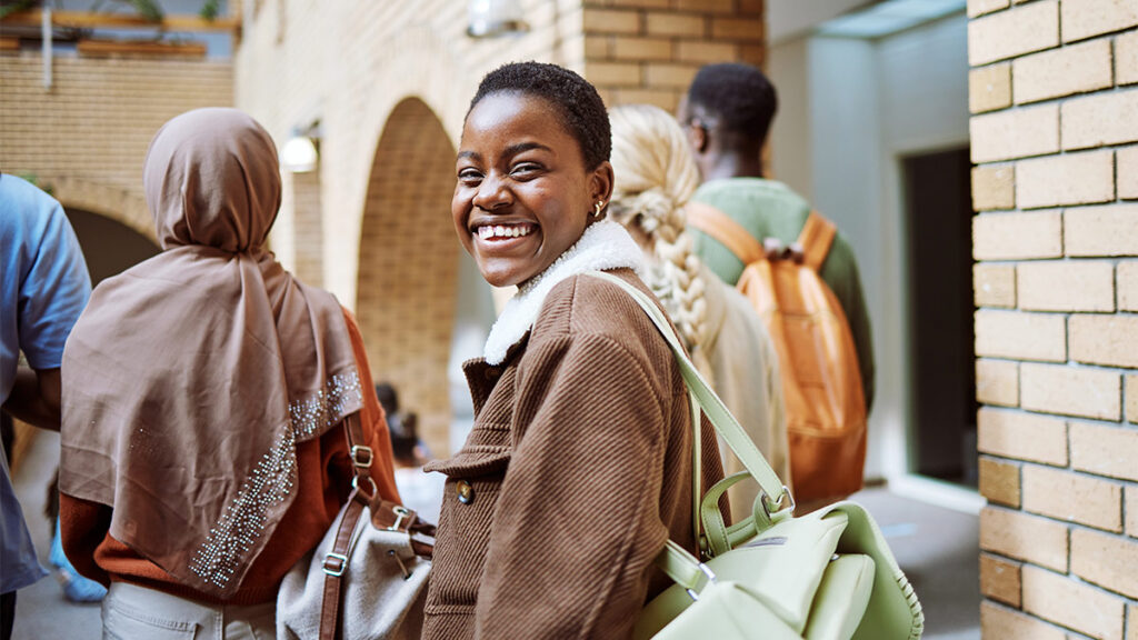 Young woman smiling at camera for a blog about How to Help Underserved Communities Through Financial Inclusion