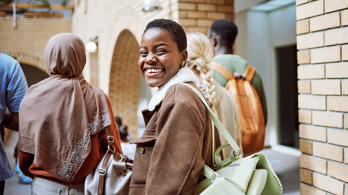 Young woman smiling at camera for a blog about How to Help Underserved Communities Through Financial Inclusion