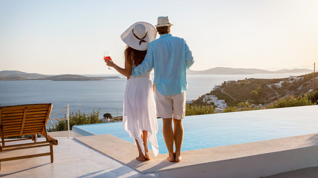 high class couple on balcony with pool and ocean views for a blog about credit score secrets