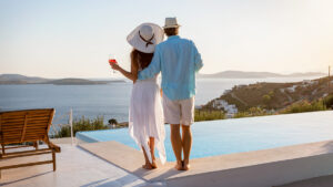 high class couple on balcony with pool and ocean views for a blog about credit score secrets