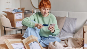 Person sitting on living room floor surrounded by packages for a blog about bad financial decisions