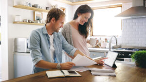 man and woman at kitchen counter taking an online budgeting quiz