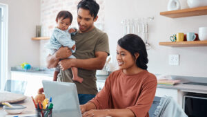 young family in home looking at laptop for a blog that discusses mid year financial check up tips